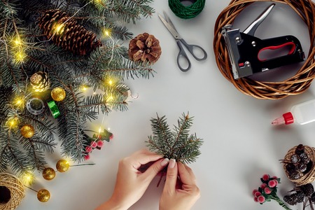 Christmas background with decorations, garland and pine cones. Creating wreath made of christmas tree branches on white background.の写真素材