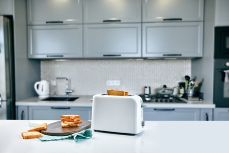 Hot morning in a white kitchen with fresh toastの写真素材