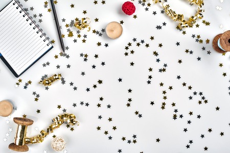 Flat Lay Christmas or Party Background with colored ribbons, decorations, confetti, and wrapping paper. Notepad for Textの写真素材