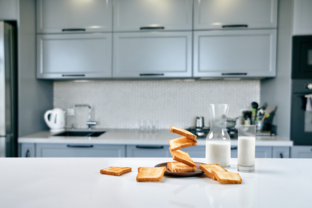 Served table for breakfast with toast, milk and honey, on blurred backgroundの写真素材