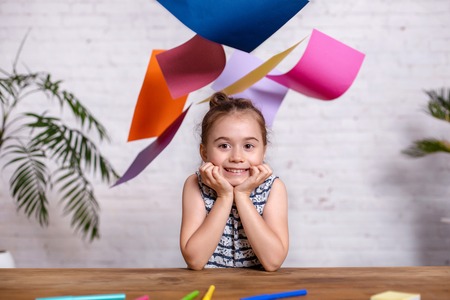Cute little girl with the colored paper