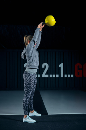 Young woman exercising with kettle bells at the gym.の写真素材