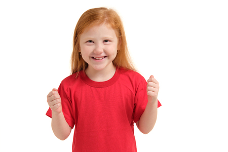 Cheerful little girl, look so excited she is raising her fists up, isolated on white background.の写真素材
