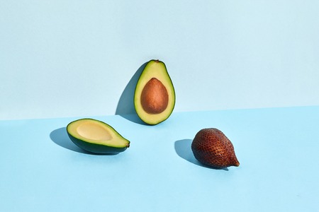 Avocado and Salacca fruits on blue backgroundの写真素材