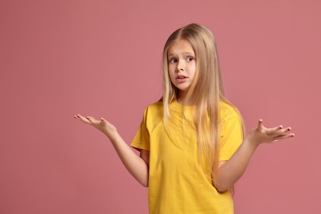 little girl in a yellow t-shirt. throws up her hands