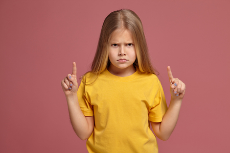 little girl in a yellow t-shirt. points finger