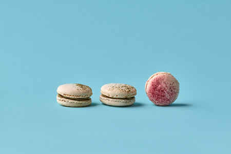 White macarons cake with colorful powder, top view, flat lay, sweet macaroon on blue background. Minimal concepts macaroons pattern above, food backgroundの写真素材