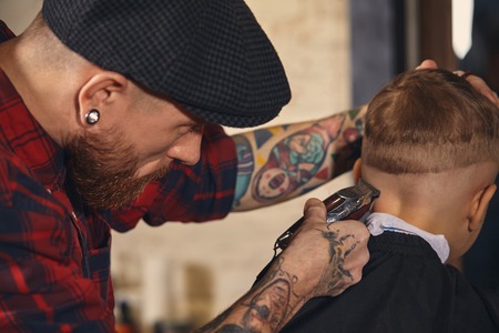 Caucasian boy getting haircut in barbershop indoorの写真素材