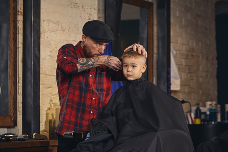 Caucasian boy getting haircut in barbershop indoorの写真素材