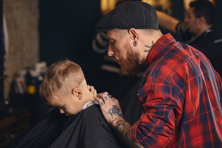 Caucasian boy getting haircut in barbershop indoorの写真素材