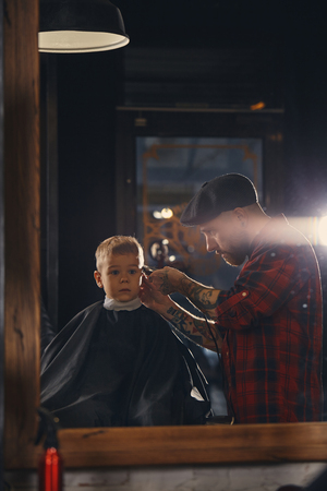 Caucasian boy getting haircut in barbershop indoorの写真素材
