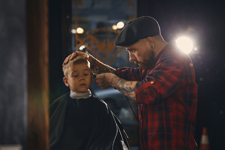 Caucasian boy getting haircut in barbershop indoorの写真素材