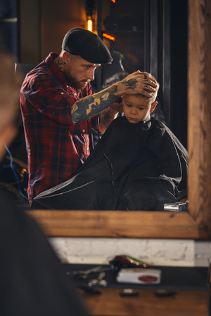 Caucasian boy getting haircut in barbershop indoorの写真素材
