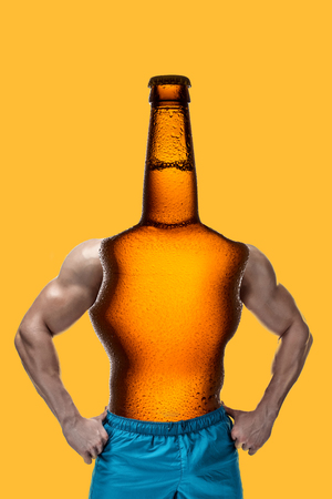Modern collage. Concept man with bottle beer body and head, muscular arms on yellow background.の写真素材