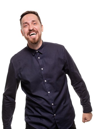 Portrait of a handsome, unshaven man, dressed in a dark blue shirt, standing against a white background. Self confident man.の写真素材