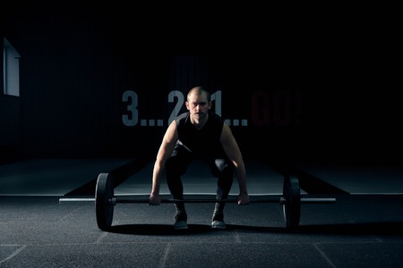 Muscular man bodybuilder training in gym and posing.