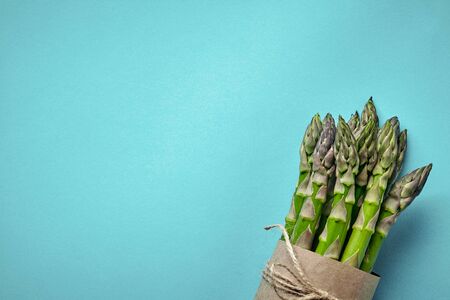 An edible, raw stems of asparagus on blue background.の写真素材