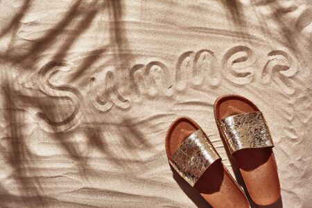 Traveler vacation accessories are laid out on a white beach sand. Flat lay, top view.の写真素材