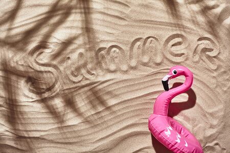 Traveler vacation accessories are laid out on a white beach sand. Flat lay, top view.の写真素材