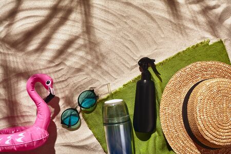 Traveler vacation accessories are laid out on a white beach sand. Flat lay, top view.の写真素材