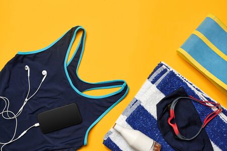 Flat lay summer pool accessories on a yellow background. Colorful beach wear.の写真素材