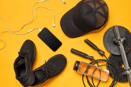 Close-up studio shot of a gym accessories on a yellow background. Top view, flat lay.の写真素材
