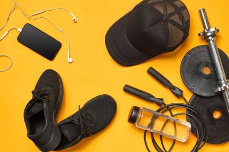 Close-up studio shot of a gym accessories on a yellow background. Top view, flat lay.の写真素材