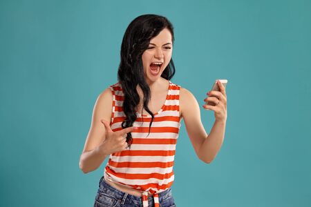Studio photo of a gorgeous girl teenager posing over a blue background.
