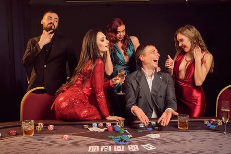 Group of a young wealthy friends are playing poker at a casino.の写真素材