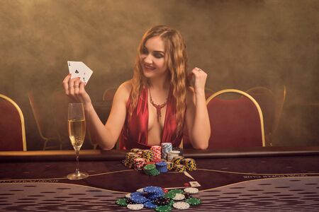 Charming woman with a beautiful hairstyle and perfect make-up is playing poker. Casino.