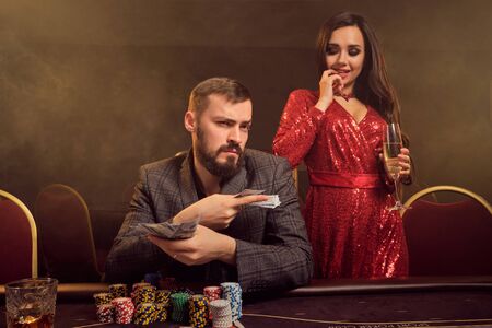 Charming wealthy couple are playing poker at a casino.の写真素材