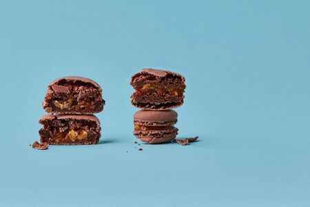 Close-up studio shot of tasty chocolate macarons on blue background.の写真素材