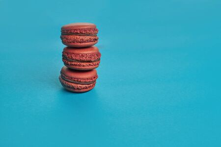 Colored macaron or macaroon, sweet meringue-based confection on blue background. Close-up, copy space.の写真素材