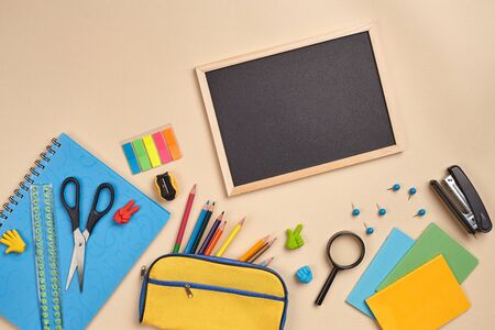 Flat lay photo of workspace desk with school accessories or office supplies on pink background.の写真素材