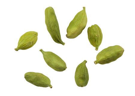 Handful of a green cardamon pods isolated on white background with copy space for text or images. Used as flavorings in both food and drink, as cooking spices and as a medicine. Frame composition, close-up shot.の写真素材