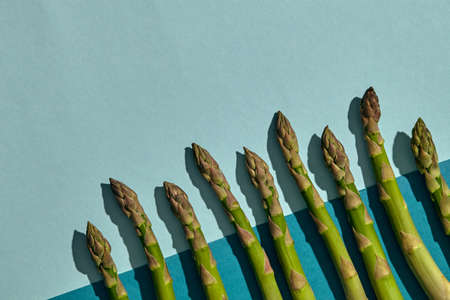 Ripe raw asparagus stalks on colorful background. Concept of healthy food and crop of spring...