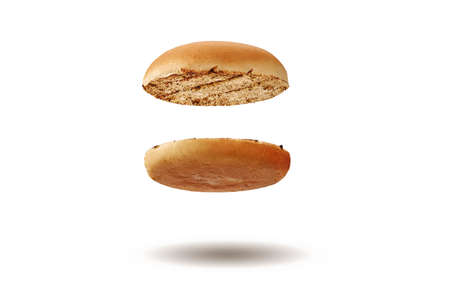 Flying and appetizing, baked or grilled, cut in half burger bun isolated on white background....