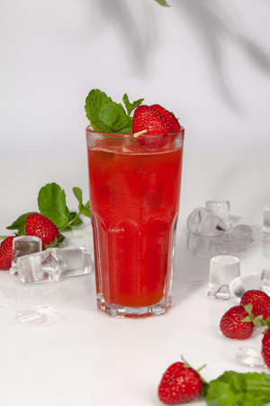 Drink with fresh strawberries and passion fruit in glass with ice and fresh mintの写真素材