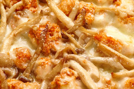Closeup of pizza with Buffalo chicken and mushrooms in creamy cheese sauce