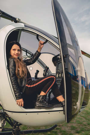 Smiling tween girl sitting on copilot seat in helicopterの写真素材