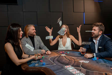 Happy young woman tossing banknotes in air while winning poker game