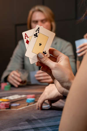 Two aces in hand of woman playing poker at gaming tableの写真素材