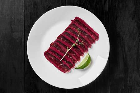 Sliced spicy air-dried cured beef basturma with lime