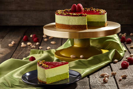 Sliced pistachio cheesecake with raspberry jelly with berries