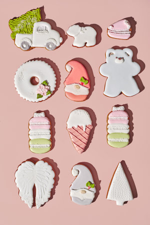 Gingerbreads of different shapes with sugar icing on pinkish background