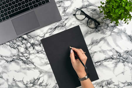 Top view in focus with different office equipment, supplies, stationery. Marble table with copy...