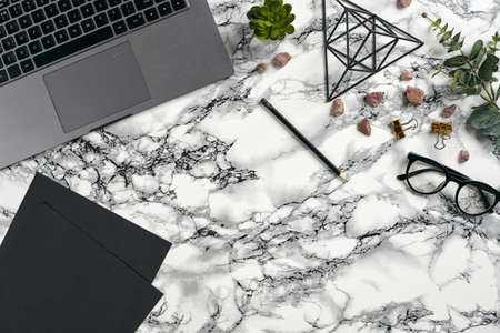 Top view in focus with different office equipment, supplies, stationery. Marble table with copy...