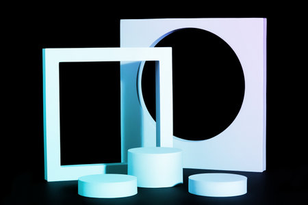 Light blue cylindrical platformes and square on black backgroundの写真素材