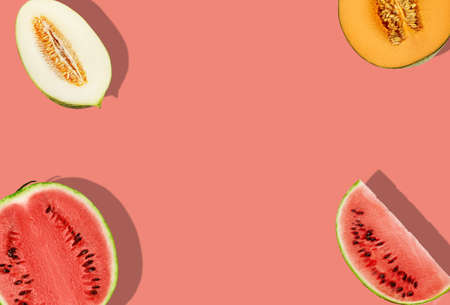 Delicious melons of different varieties and watermelon, halves and slices, on pink background with copy space for text or images. Close-up, top view.の写真素材