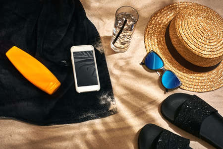 Summer background with straw hat, sunglasses, sunscreen bottle and flip flops